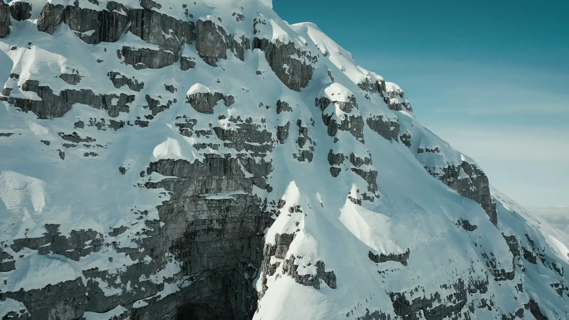 Snow-covered mountain ridge beneath an open sky.