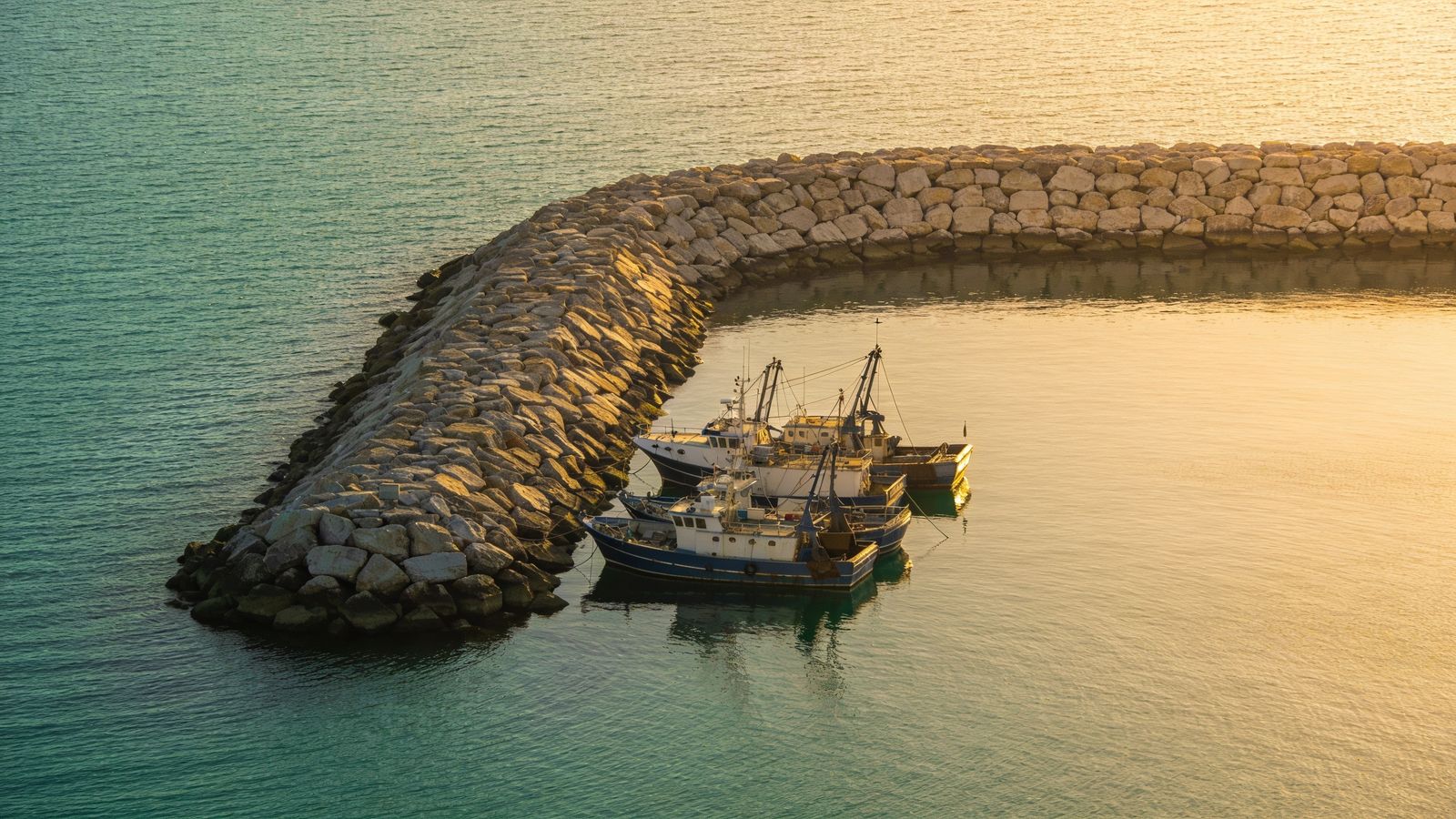 Stone breakwater sheltering fishing boats