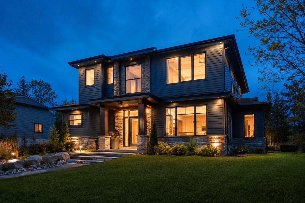 A modern Canadian home at dusk with warm light in the windows.